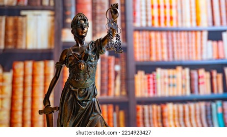 Lawyer Office. Statue Of Justice With Scales Close-up Against The Backdrop Of A Wall Of Books Or A Library . Legal Law, Advice And Justice Concept