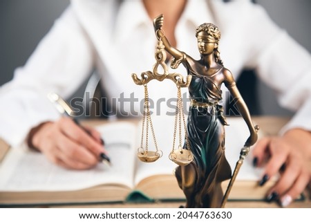 Lawyer office. Statue of Justice with scales and lawyer working