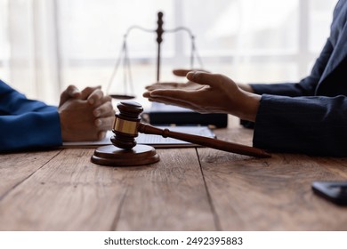 Lawyer is providing legal advice to a client. Legal advisor is discussing and explaining the terms of the legal agreement contract document before signing. Legal processing services. - Powered by Shutterstock