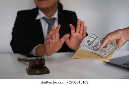 Lawyer is refusing a bribe from his client who is offering him a wad of cash. Full of integrity. Fight against corruption, bribery
