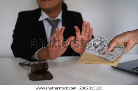 Lawyer is refusing a bribe from his client who is offering him a wad of cash. Full of integrity. Fight against corruption, bribery

