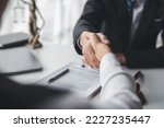 Lawyer shaking hands with a client making about documents, contracts, agreements, cooperation agreements with a female client at the lawyer