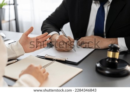 Lawyer signing contract, professional lawyer in law firm office drafting legal document or contract agreement ensuring lawful protection for client's disputes as fairness advocate concept. Equilibrium