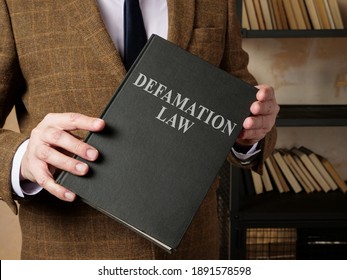 Lawyer In Suit Holds Defamation Law Book.