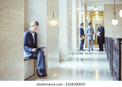 Lawyer working on digital tablet in courthouse - Shutterstock ID 2328300055