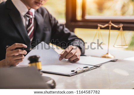 lawyer working on wooden desk with gavel and soundblock of justice law