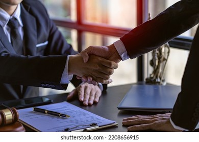 Lawyers closely shake hands with clients on successful resolutions of cases, law, counseling, agreements, contracts. - Shutterstock ID 2208656915