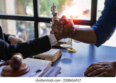 Lawyers closely shake hands with clients on successful resolutions of cases, law, counseling, agreements, contracts. - Shutterstock ID 2208656917