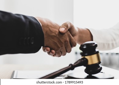 Lawyers or counselors shake hands with clients to congratulate the end of the case by the company, Negotiation or settlement of lawsuits concept.