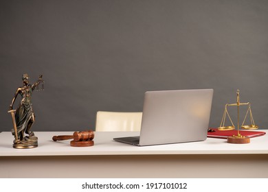 Lawyers Desk. Judge's Gavel, Statue Of Justice, Scales, Wooden Table. Gray Bokeh Background.