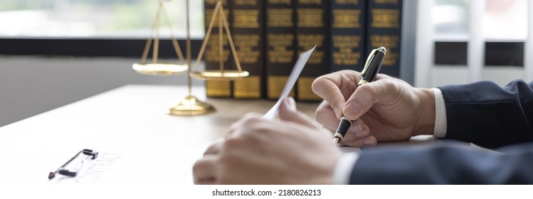 Lawyers or judges sign documents in accordance with legal and fair terms of agreement, Legal Ethics and Integrity, scales of justice, law hammer, Litigation and legal services. - Shutterstock ID 2180826213