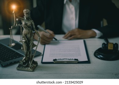 Lawyer's Office Scales Of The Goddess Of Justice Lawbook And Lawyer Page. Law Concept. Judge's Hammer, Old Courtroom Library. Wooden Table.