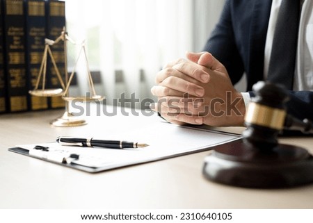 The lawyers sitting in their office is meticulously examining the judicial documents to gather crucial information and build a strong legal strategy for their client's case. Stock photo © 