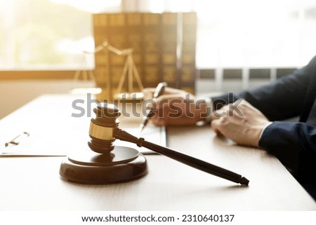 The lawyers sitting in their office is meticulously examining the judicial documents to gather crucial information and build a strong legal strategy for their client's case. Stock photo © 