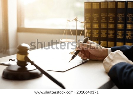 The lawyers sitting in their office is meticulously examining the judicial documents to gather crucial information and build a strong legal strategy for their client's case.