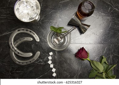 Lay Flat Overhead Of Bar Countertop With Deconstructed Elements Of Kentucky Derby Mint Julep With Horse Shores And Red Rose.