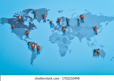 Lay flat top view of miniature backpacker travellers visit various countries in on world map concept.