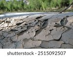 Layer of soil carried away by flood waters or streams. Sediment deposits and cracks near the stream bed. Alluvium surface on the ground.