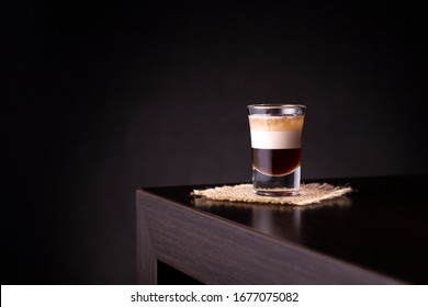 Layered B 52 Cocktail Shot On A Burlap Coaster Placed On A Bar Counter With Copy Space