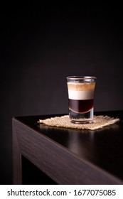 Layered B 52 Cocktail Shot On A Burlap Coaster Placed On A Bar Counter With Copy Space