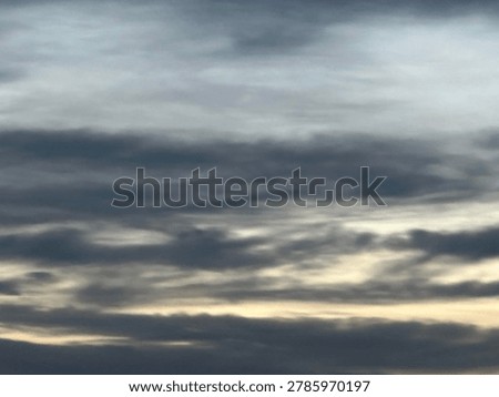 Layered clouds at sunset creating atmospheric natural sky scene and outdoor weather background