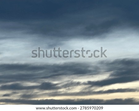 Layered clouds at sunset creating atmospheric natural sky scene and outdoor weather background