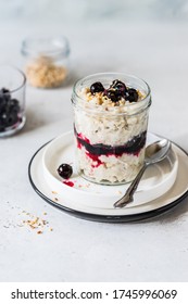 Layered Creamy Oat Porridge in a Jar with Blackcurrants and Chopped Almonds, copy space for your text