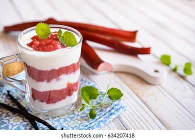 Layered dessert with yoghurt and rhubarb puree in a glass cup