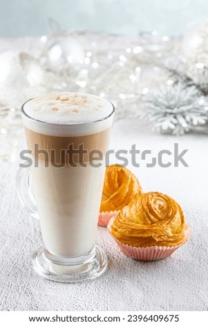 Layered latte coffee on  the festive Christmas table. Cozy home atmosphere, white background, copy space for text. Winter Christmas  holidays treats concept
