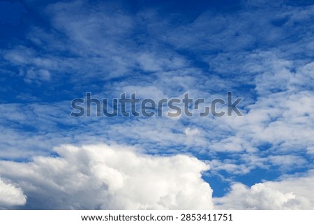 layered pattern of small white clouds covers the entire blue sky, with a denser and more volumetric cumulus cloud situated at the bottom of the photo