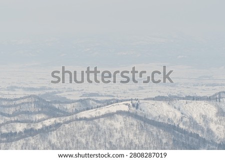 Layered ridgelines dissolving into winter haze, Hokkaido, Japan