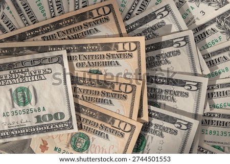 Layered Stack of US Currency Featuring 100, 10, and 5 Dollar Bills
