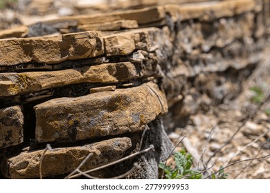 Layered structure of rocks. Close up of stone formation structured from flat stones and grown moss on rock surface. Types of stone formations. Copy space