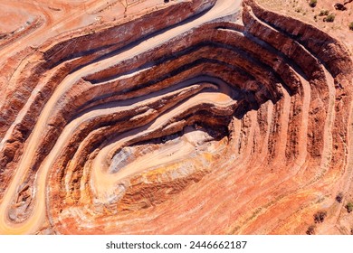 Layers of deep open pit copper mine in Cobar town of outback Australia - aerial top down view.
