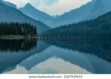 Layers of Two Medicine Reflects In The Still Lake Below the mountains