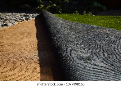 Laying artificial grass turf onto sand in a back garden yard