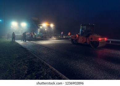 Laying Asphalt Paver At Night With Headlights. Road Construction.