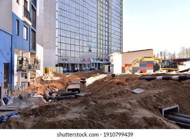 Laying Concrete Manholes And Heating Drain Pipes And For Stormwater System In Trench At Construction Site. Sewerage Manhole And Pipes Line Under Construction. Chambers And Pump Station