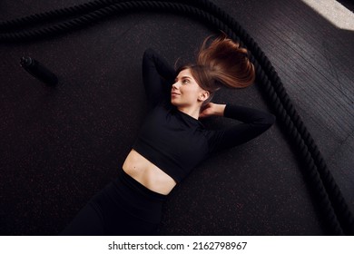 Laying Down And Taking A Break. Top View. Young Beautiful Woman In Sportive Clothes Have Fitness Day In The Gym.