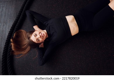 Laying Down And Taking A Break. Top View. Young Beautiful Woman In Sportive Clothes Have Fitness Day In The Gym.