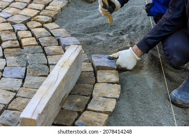 Laying Granite Cubes Stone Pavement On The A City Street With Construction Road Worker