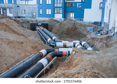 Laying Heating Pipes In A Trench At Construction Site. Install Underground Storm Systems Of Water Main And Sanitary Sewer. Cold And Hot Water, Heating And Heating System Of Apartments In The House