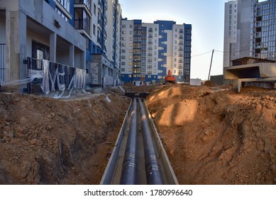 Laying Heating Pipes In A Trench At Construction Site. Install Underground Storm Systems Of Water Main And Sanitary Sewer. Cold And Hot Water, Heating And Heating System Of Apartments In The House