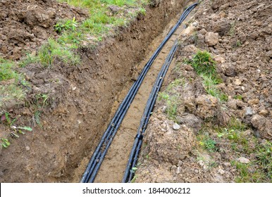 laying high voltage cables to the ground. the environment does not damage electric poles. Excavation meter deep in the ground black plastic coated strong cable wires. risk of electric shock in case of