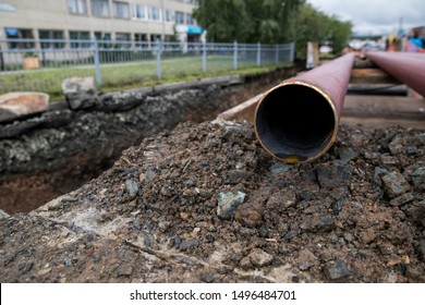 Laying or replacement of underground storm sewer pipes. Installation of water main, sanitary sewer, storm drain systems in city. Cast iron drainage pipe in ditch. 