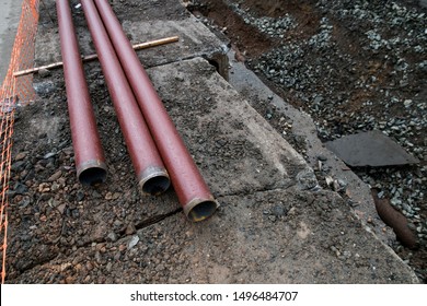 Laying or replacement of underground storm sewer pipes. Installation of water main, sanitary sewer, storm drain systems in city. Cast iron drainage pipe in ditch.  - Shutterstock ID 1496484707
