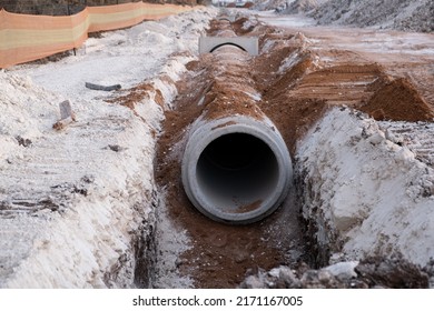 Laying Sewer Concrete Drainage Pipe Between Large Residential Areas. New Sanitary Sewer, Storm Drain Systems On Construction Site.