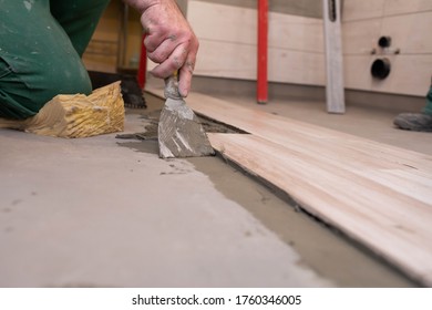 Laying Terracotta In The Bathroom. Builder During Work. Adhesive For Ceramic Tiles.