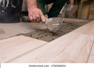 Laying Terracotta In The Bathroom. Builder During Work. Adhesive For Ceramic Tiles.