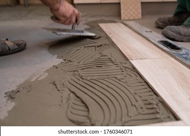 Laying Terracotta In The Bathroom. Builder During Work. Adhesive For Ceramic Tiles.